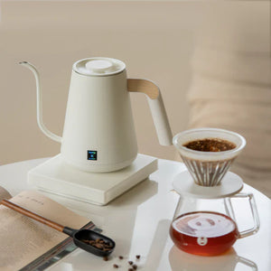 Bouilloire électrique blanche avec bec étroit et détail en bois pour un versement précis lors de la préparation du café, tout sur le café.