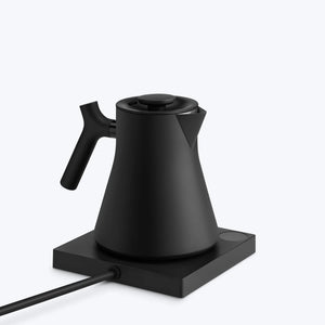 Bouilloire noire mate avec poignée ergonomique sur plaque chauffante, partie de Fellow, EspressoGear, tout sur le café