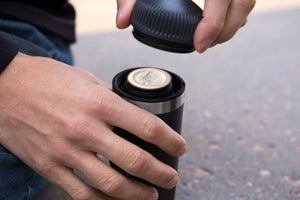Gros plan sur une main insérant un adaptateur de capsule dans une cafetière Portable, catégorie barista et espresso.