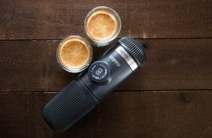 Machine à espresso portable avec deux tasses d'espresso sur une surface en bois, provenant de cafetières portables et d'équipements de barista